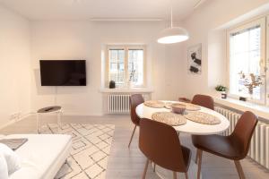 una sala de estar blanca con mesa y sillas en ULEABO New, Light and Roomy 61m² Apartment With Sauna!, en Oulu