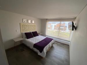 a bedroom with a bed and a large window at SU CASA PARA DESCANSO EN FAMILIA Y/O TRABAJO in Paipa