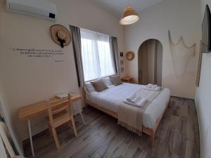 sypialnia z dużym łóżkiem i oknem w obiekcie ARCO VESUVIANO w mieście Madonna dellʼArco