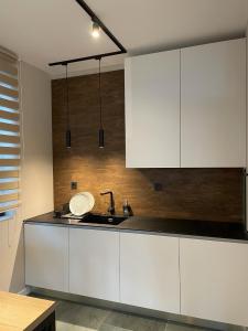 a kitchen with white cabinets and a sink at Buena Vista Villas in Varna City