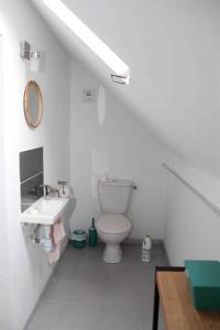 uma casa de banho branca com um WC e um lavatório em La Patelle em Barneville-Carteret