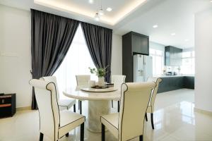 een keuken en eetkamer met een tafel en stoelen bij Desaru KTV Classical Elegant Style by Joyfully 2M2 in Desaru
