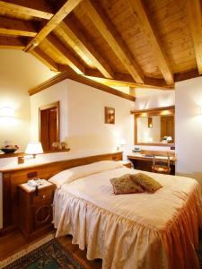 a bedroom with a large bed and a large window at Hotel Columbia & Spa in Cortina dʼAmpezzo