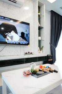 a white table with a tv on a wall at Desaru KTV Classical Elegant Style by Joyfully 2M2 in Desaru