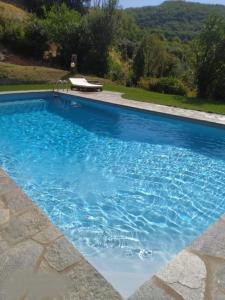 a large swimming pool with blue water at Stanze Blu in Subbiano