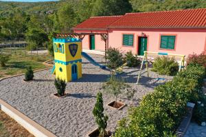 a playground in front of a house with a slide at Villa Lujko in Prapatnica