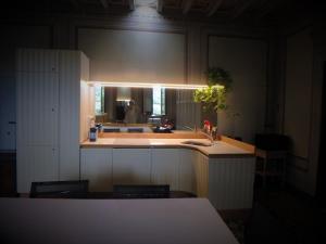 eine Küche mit Spüle und eine Person im Spiegel in der Unterkunft Villa San Simone in Pistoia