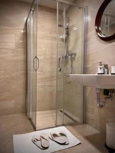a bathroom with a shower and a sink and two slippers at Harfa Apartment 30 in Prague