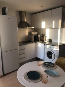 a small kitchen with a table and a refrigerator at Apartmento studio boho a 1 minuto del puerto y la playa! in Jávea