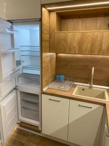 a kitchen with an empty refrigerator and a sink at Arletti Luxury Apartment in Ruse