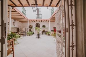 einen offenen Flur mit Pflanzen in einem Gebäude in der Unterkunft Posada La Casa Del Pintor in Carmona