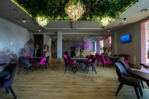 un restaurante con mesas, sillas y sillas rosas en Hostynnyy Dvir en Stryi
