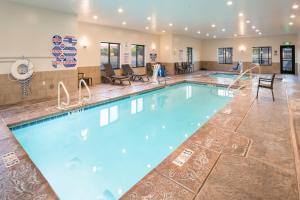 a pool in a hotel lobby with chairs and tables at Sleep Inn & Suites Hurricane Zion Park Area in Hurricane