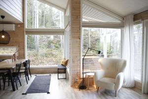 - un salon avec une table, des chaises et des fenêtres dans l'établissement Villa Laidike with sauna/fireplace, 80 km Helsinki, à Suomusjärvi