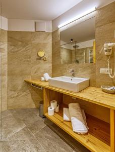 uma casa de banho com um lavatório e um espelho em Hotel Rose em Villabassa