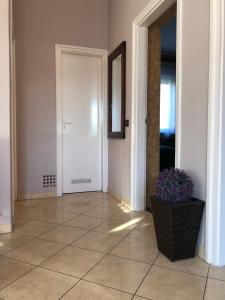 a hallway with a door and a vase of purple flowers at Kelemen Nyaraló Balatonmáriafürdő in Balatonmáriafürdő