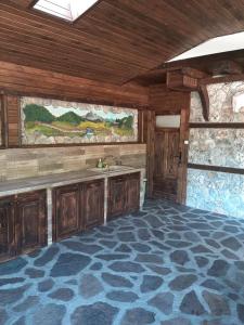 a kitchen with wooden cabinets and a sink in a room at Къща за гости "Мегдана на Чаршията" in Smilyan