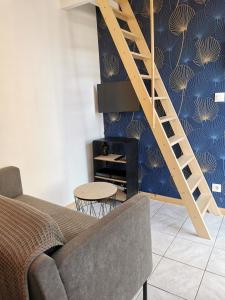 ein Wohnzimmer mit einer Treppe und einer Couch in der Unterkunft Le 5 in Plouézec