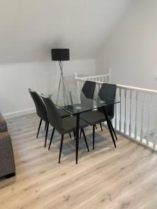 een glazen tafel en stoelen in de woonkamer bij Peartree Lodge in Cambourne