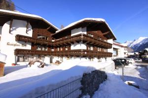 ein schneebedecktes Gebäude mit einem Zaun in der Unterkunft Gurglerhof in Sölden