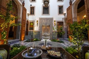 a courtyard with a fountain in a building at Riad Sidrat Fes in Fez