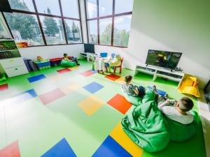 two children laying on the floor in a room at Apartman Kraljevi cardaci 5b-32 in Kopaonik