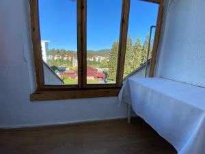 Habitación con ventana y mesa. en Apartament Viva Predeal, en Predeal