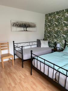 a bedroom with two beds and a chair in it at familienfreundliche Ferienwohnung Maria in Duderstadt