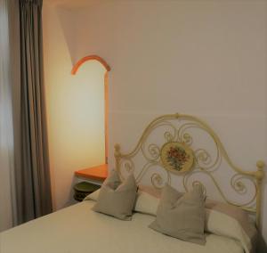 a bedroom with a white bed with pillows at Appartamento Antico Pozzo in Prato +9 photos