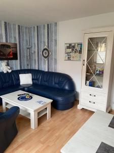 een woonkamer met een blauwe bank en een salontafel bij familienfreundliche Ferienwohnung Maria in Duderstadt