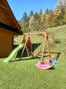 um parque infantil com um escorrega e um baloiço em Domek pod Groniem em Mizerna