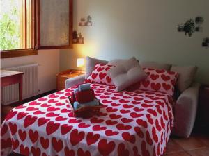 Una cama roja y blanca con un osito de peluche. en Green Nest, en Farra di Soligo