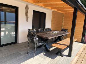 a wooden deck with a wooden table and chairs at Landhaus Osttirol in Iselsberg
