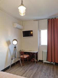 um quarto com uma secretária, um candeeiro e uma câmara em Hotel Café de la Gare em Sainte-Foy-la-Grande