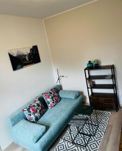 una sala de estar con un sofá azul en una habitación en FeWo Alte Bäckerei, en Dessau