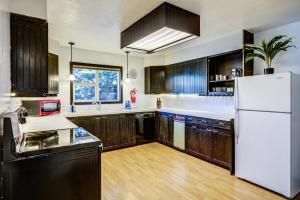 a kitchen with wooden cabinets and a white refrigerator at Geyser Getaway in West Yellowstone