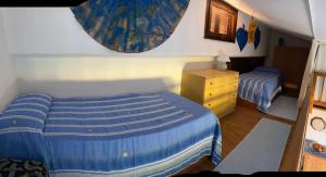 圣特奥多罗villino D5 coda cavallo villaggio cala paradiso的一间卧室配有蓝色的床和梳妆台