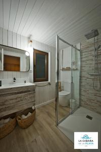 Un baño con bañera, lavabo y ducha. en La Cabaña de la playa, en Ajo