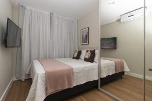 um quarto com uma cama e um espelho em Casa belaju em Aracaju