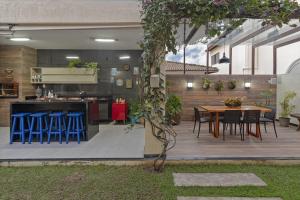 an outdoor kitchen and dining area with a wooden deck at Casa belaju in Aracaju