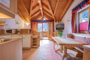 cocina con techo de madera y mesa en Ferienhaus Artho, en Neustift im Stubaital