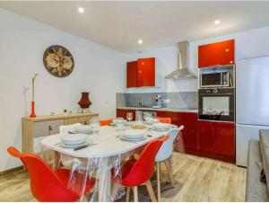 een keuken met een witte tafel en rode kasten bij Ceriflor-Le Vignemale in Cauterets