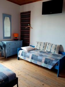 a bedroom with a bed and a tv on the wall at Pátio das Andorinhas in Ferreira do Alentejo