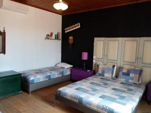 Duas camas num quarto com paredes pretas em Pátio das Andorinhas em Ferreira do Alentejo