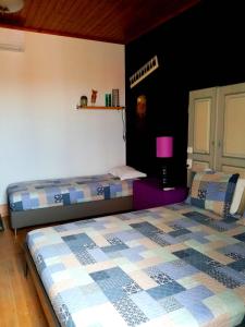 um quarto com 2 camas e uma mesa de cabeceira roxa em Pátio das Andorinhas em Ferreira do Alentejo