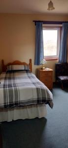 a bedroom with a bed and a window and a chair at Invernettie guesthouse in Peterhead