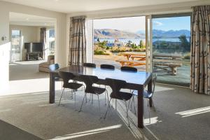 a dining room table with chairs and a view of the ocean at Blae Loch - Lake Tekapo in Lake Tekapo