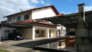 a building with a car parked in a parking lot at Flat Agradável Pomerode in Pomerode