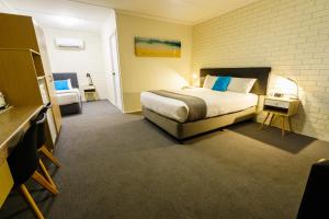 a hotel room with a bed and a desk at Comfort Inn on Main Hervey Bay in Hervey Bay