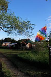 una cometa colorida sentada en el césped junto a una casa en Alojamiento Ecológico Kurache en Tandil